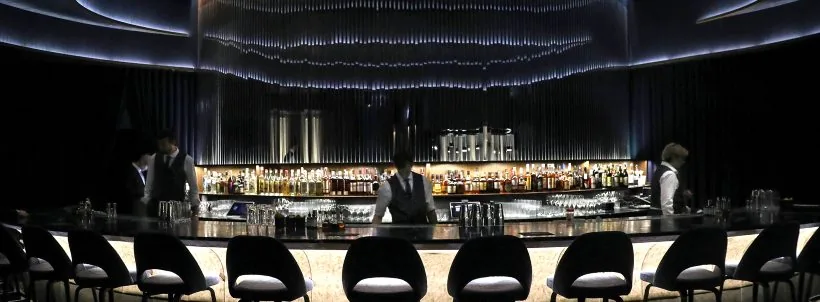 Curved cocktail bar with illuminated bottle shelves