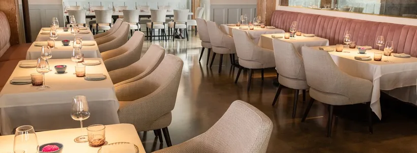 Indienne dining room in November 2022, with upholstered chairs and a pink banquette