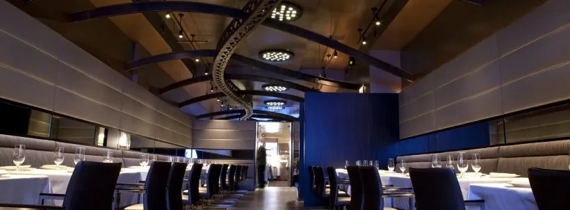 Rows of dining tables beneath a curved overhead fixture