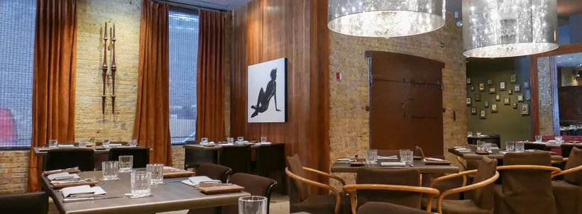 Sepia dining room in June 2017, with set tables, curtains and exposed brick